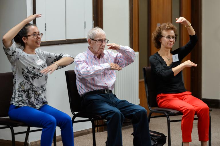 Two women and a man doing sit-down exercises