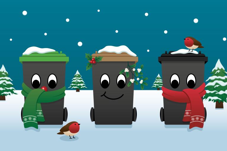 Three festive wheelie bins surrounded by snow