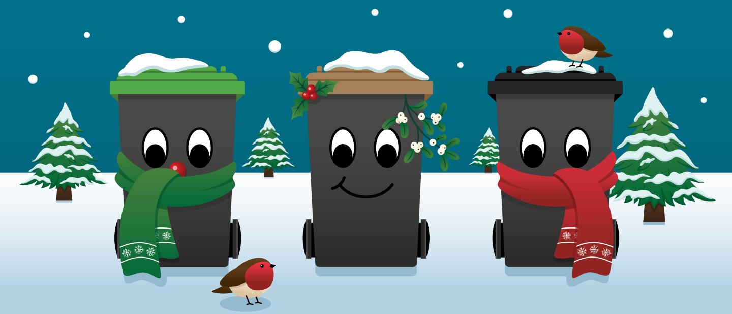 Three festive wheelie bins surrounded by snow