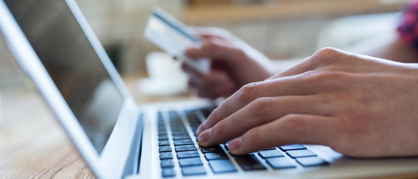 Hand using laptop to make an online payment